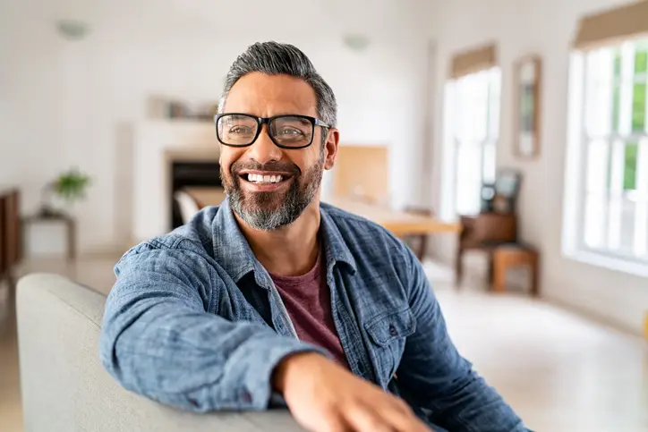 Highly confident mature ethnic man wearing eyeglasses at home